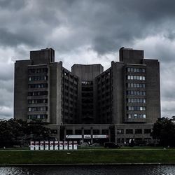 Buildings in city against cloudy sky