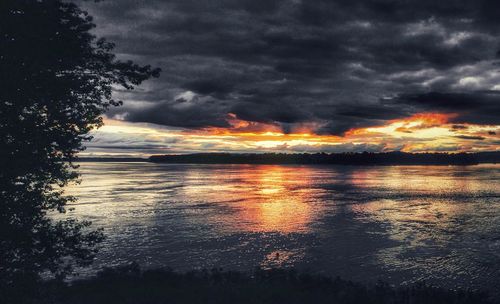 Scenic view of sea against dramatic sky during sunset