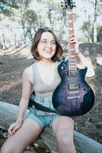 Portrait of young woman playing guitar