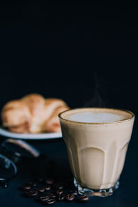 Latte art , croissant with roasted coffee on black background in the morning 