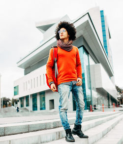 Young man standing against building in city