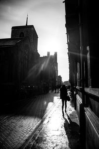 Man walking on road against sky in city