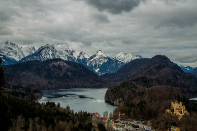 Scenic view of lake by snowcapped mountains against sky