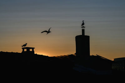Silhouette of building against sky during sunset