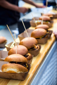 Street food many burgers with meat and cheese and french fries in craft packaging. 