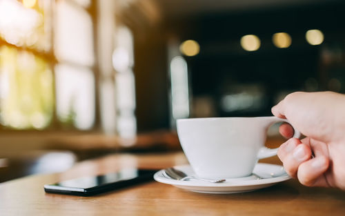 Man holding coffee cup on table