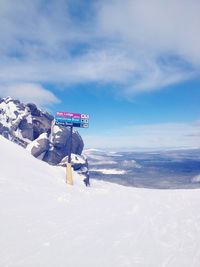 Scenic view of snow covered mountains against cloudy sky