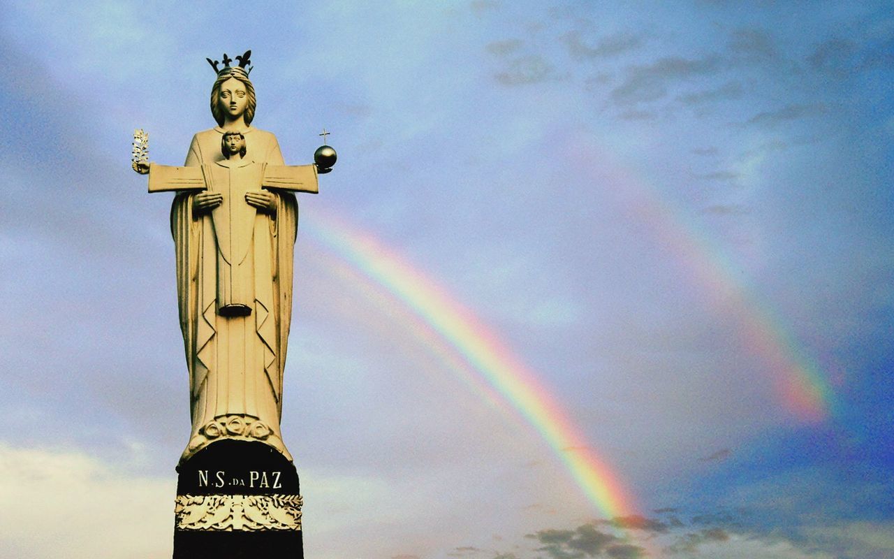 low angle view, sky, art and craft, sculpture, statue, cloud - sky, human representation, art, architecture, built structure, creativity, religion, cloud, building exterior, cloudy, outdoors, spirituality, no people, place of worship