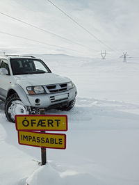 Information sign on snowcapped mountain against sky