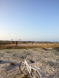 Bicycles on beach against clear sky