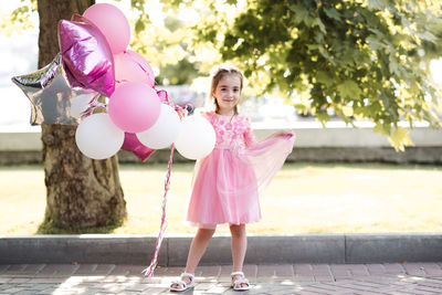 Full length of woman holding red balloons