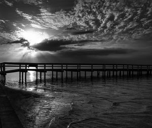 Pier on sea at sunset
