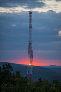 Low angle view of communications tower against sky during sunset