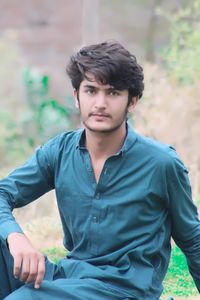 Portrait of young man sitting in park