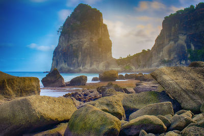 Rocks on beach against sky