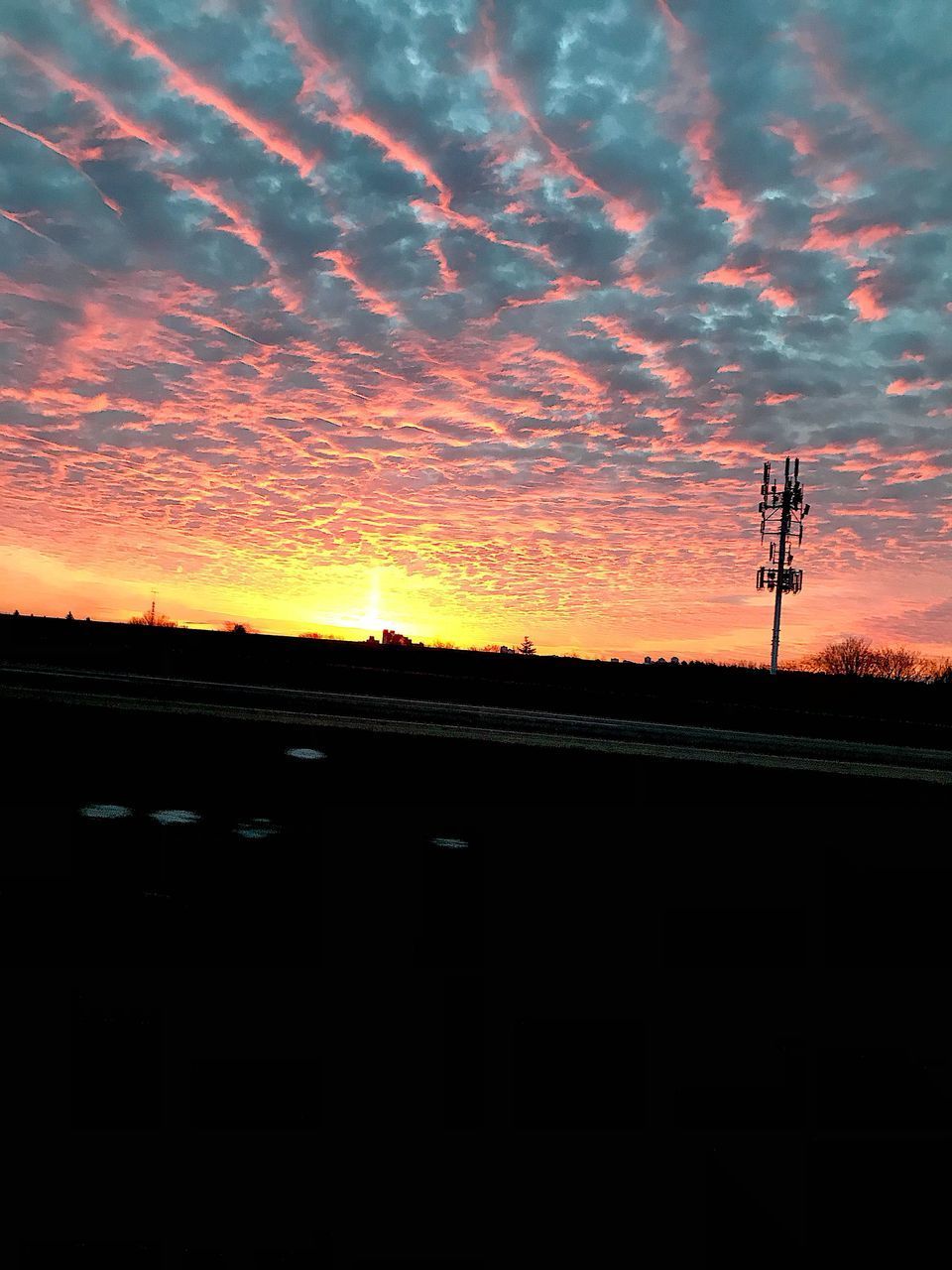 SILHOUETTE OF ELECTRICITY PYLON AGAINST DRAMATIC SKY