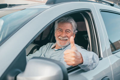 Portrait of senior man sitting in car