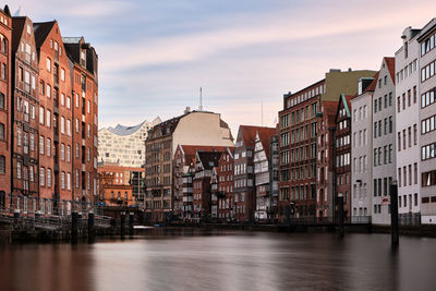 Canal amidst buildings in town against sky