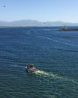 Boats sailing in sea against clear sky