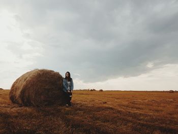 Full length of woman standing on field against sky