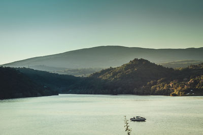 Scenic view of lake and mountains against clear sky