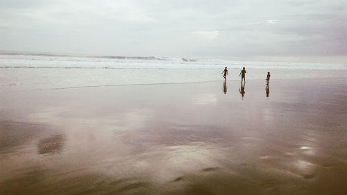 Three people on idyllic beach in indonesia