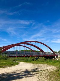 View of bridge on field against blue sky