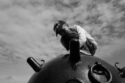 Low angle view of man wearing sunglasses against sky