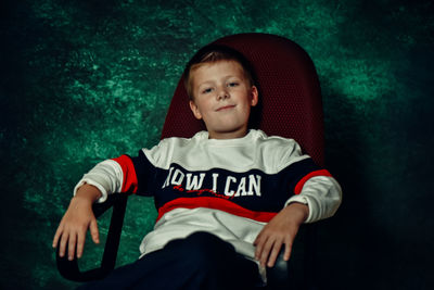 Portrait of cute boy sitting outdoors