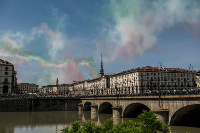 Bridge over river against cloudy sky