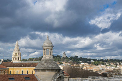 View of buildings in city against cloudy sky