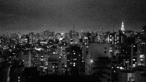 Illuminated cityscape against sky at night