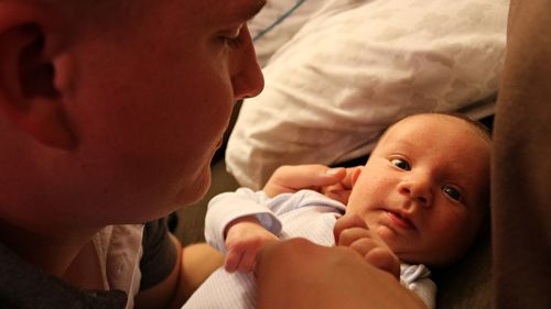 Close-up of baby lying on bed