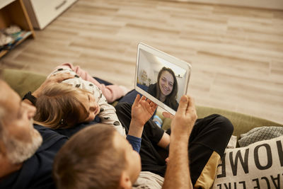 Grandfather with grandchildren doing video call on tablet pc at home