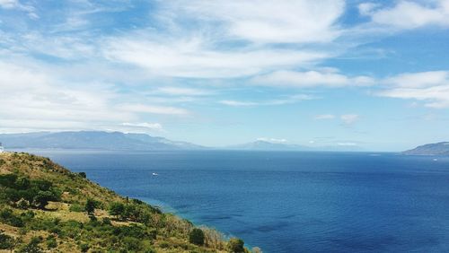 Scenic view of sea and mountains against sky