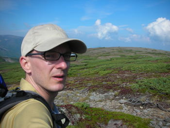 Portrait of man in cap on land against sky