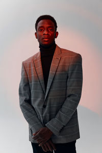 Portrait of young man standing against wall