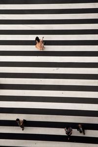 Directly above shot of people walking on zebra crossing