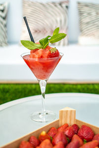 Close-up of strawberry daiquiri alcoholic cocktail drink on glass table 