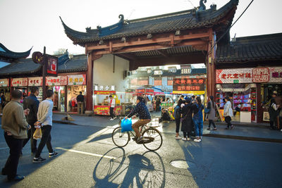 People on street against buildings in city