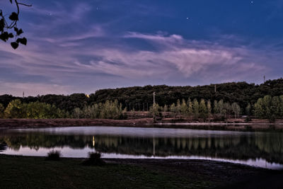 Scenic view of lake against sky at night