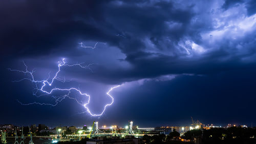 Low angle view of illuminated city against sky at night