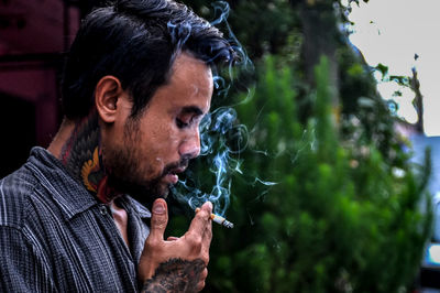 Portrait of young man smoking cigarette