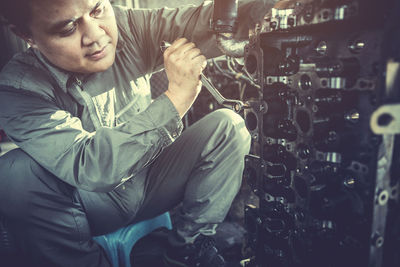 Male mechanic repairing car in workshop