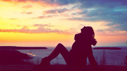 Silhouette of people on beach at sunset