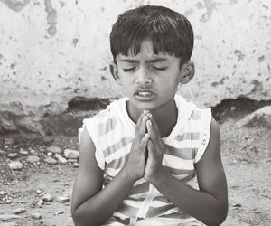 Close-up of boy with hands clasped