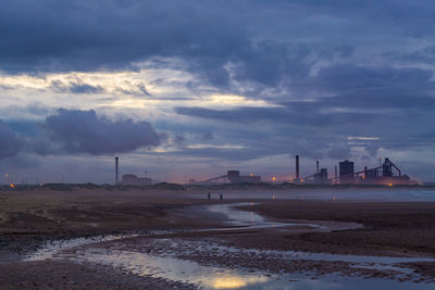 Factory against sky during sunset