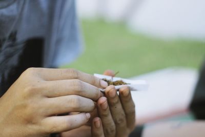 Midsection of man holding cannabis