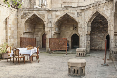 Empty chairs and tables in front of building