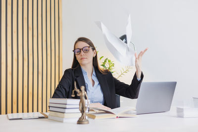 Portrait of woman using laptop while sitting on table